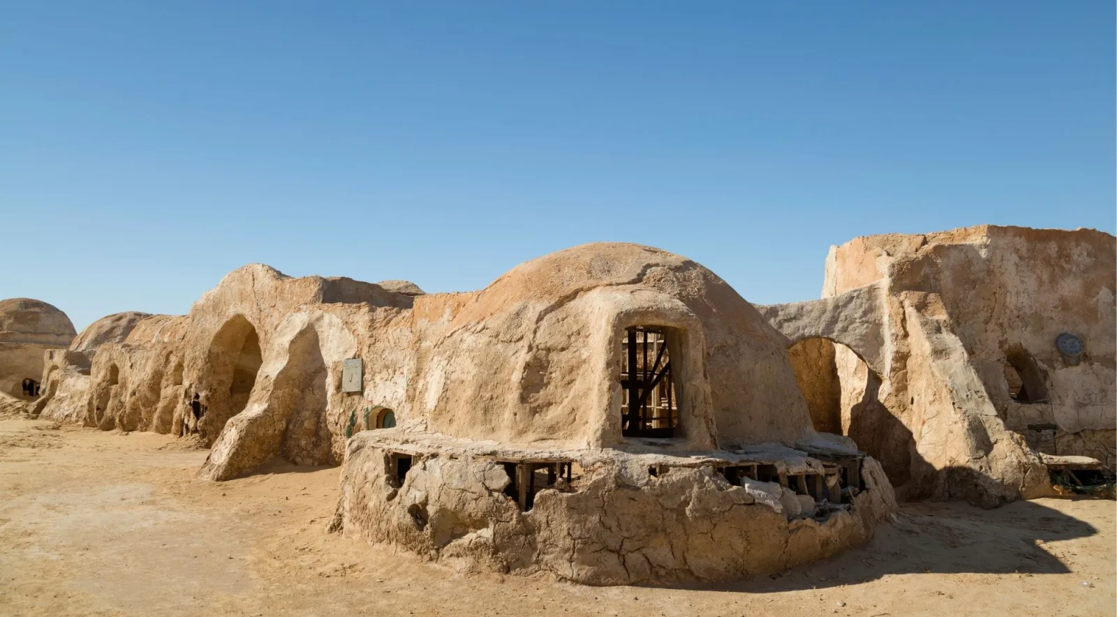 The domed and arched buildings of the Mos Espa film set standing in open desert near Nefta