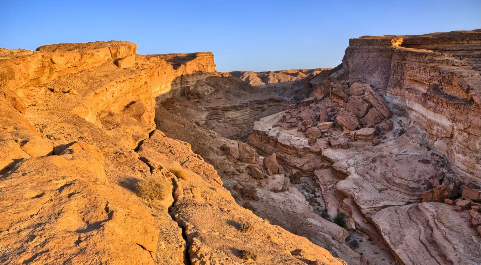 Layered red cliffs of the Tamerza and Mides canyons lit by low sun