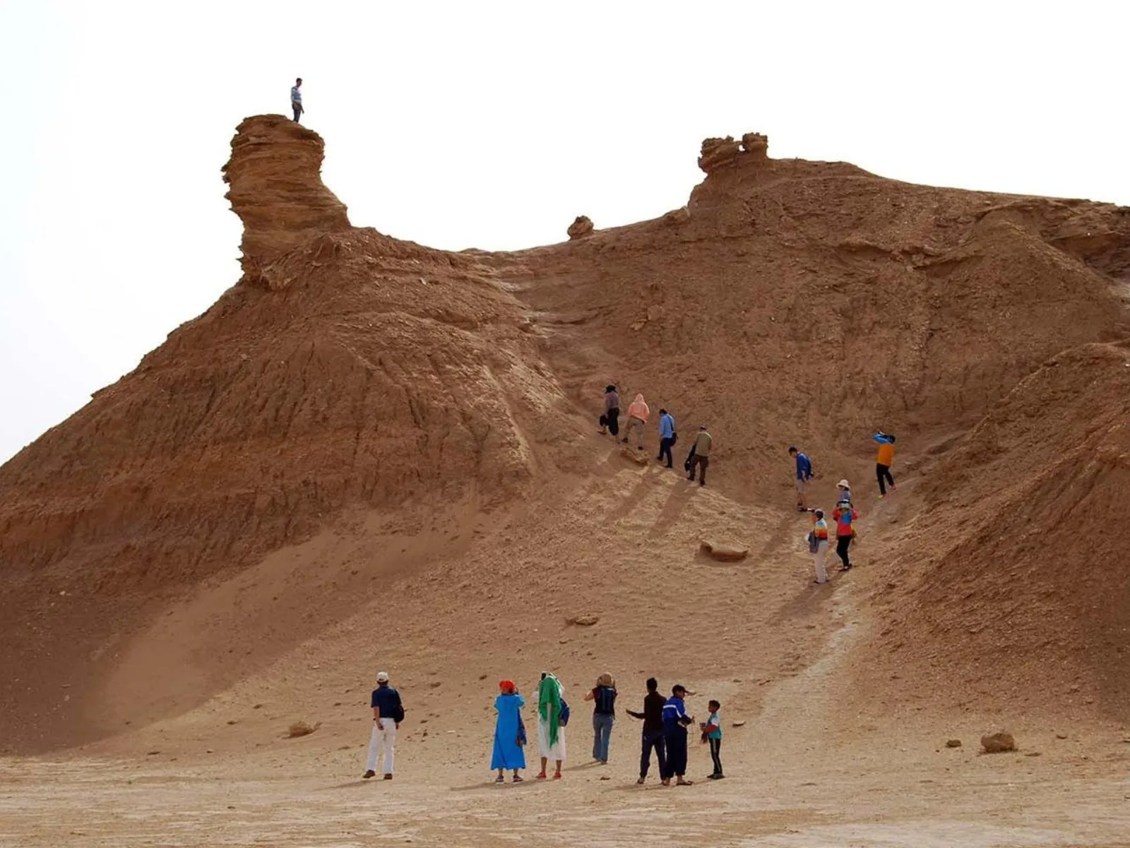 Visitors climbing the flank of Ong Jmal, with one figure on the summit rock