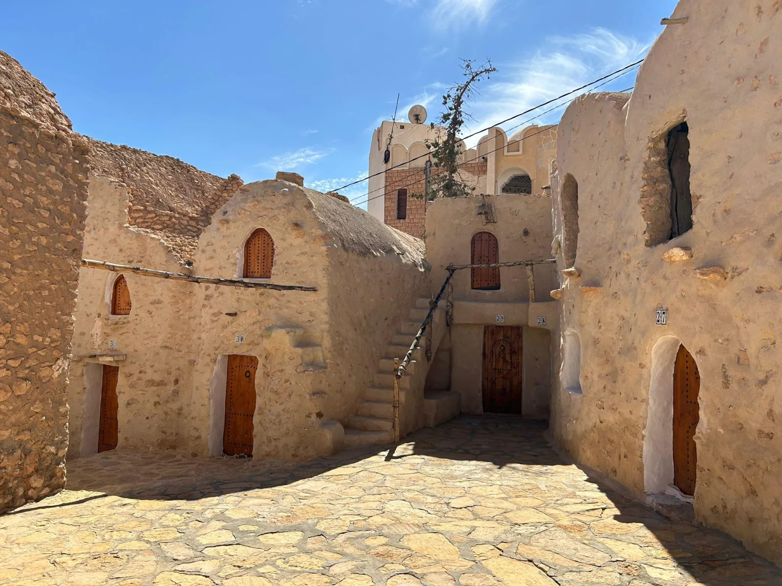 The numbered doors and external staircase of the ksar courtyard at Ksar Hadada