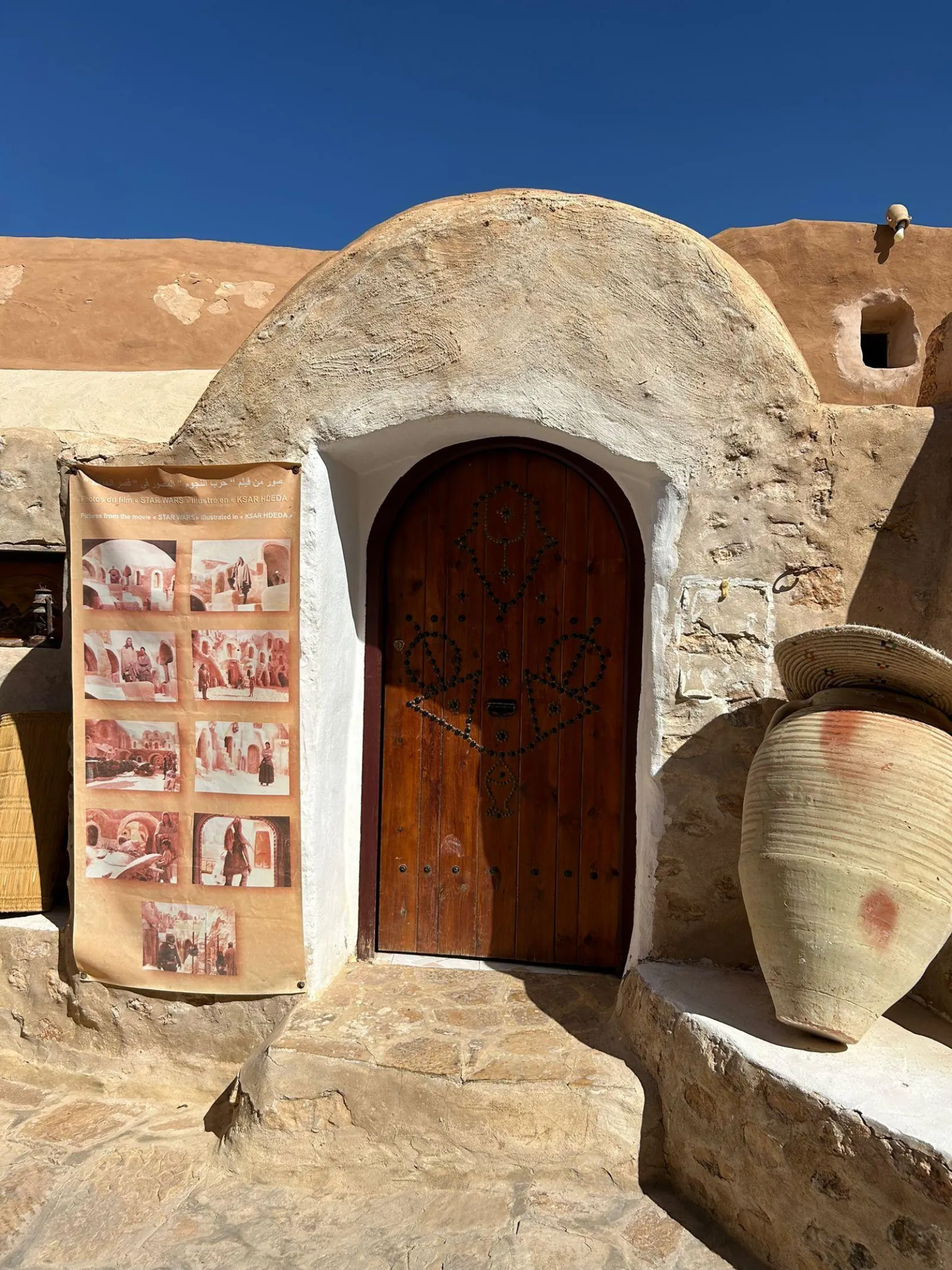 A banner of Star Wars film stills hung beside a studded wooden door at Ksar Hadada