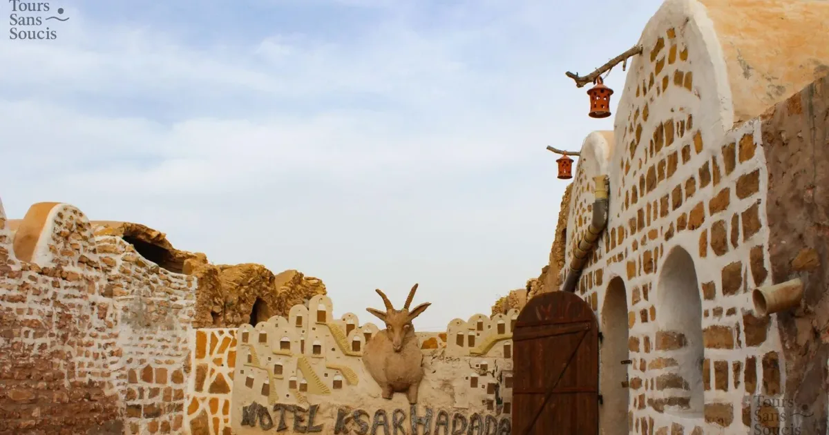 Vaulted ghorfa granary cells at Ksar Hadada near Tataouine, with the Hotel Ksar Hadada sign painted on the wall